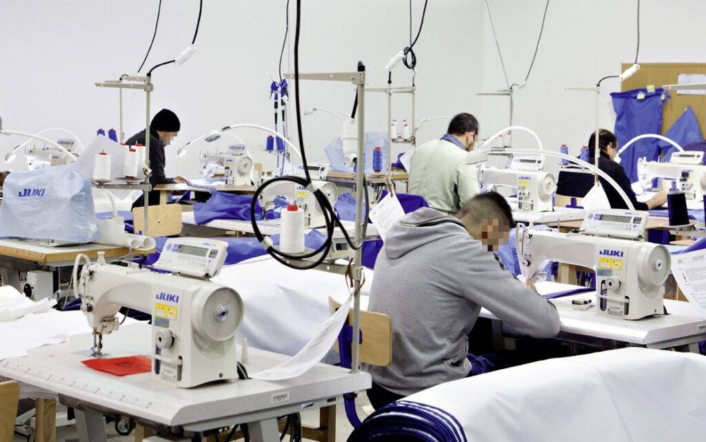 Des personnes détenues produisent des masques pour lutter contre la pandémie et contribuer à la mobilisation nationale. Atelier de confection à la prison de Val-de-Reuil.