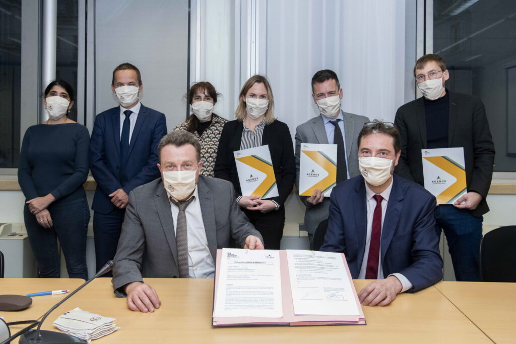 Photo de groupe avec, au premier plan, l'accord signé entre l'Atigip et la direction des achats de l'Etat