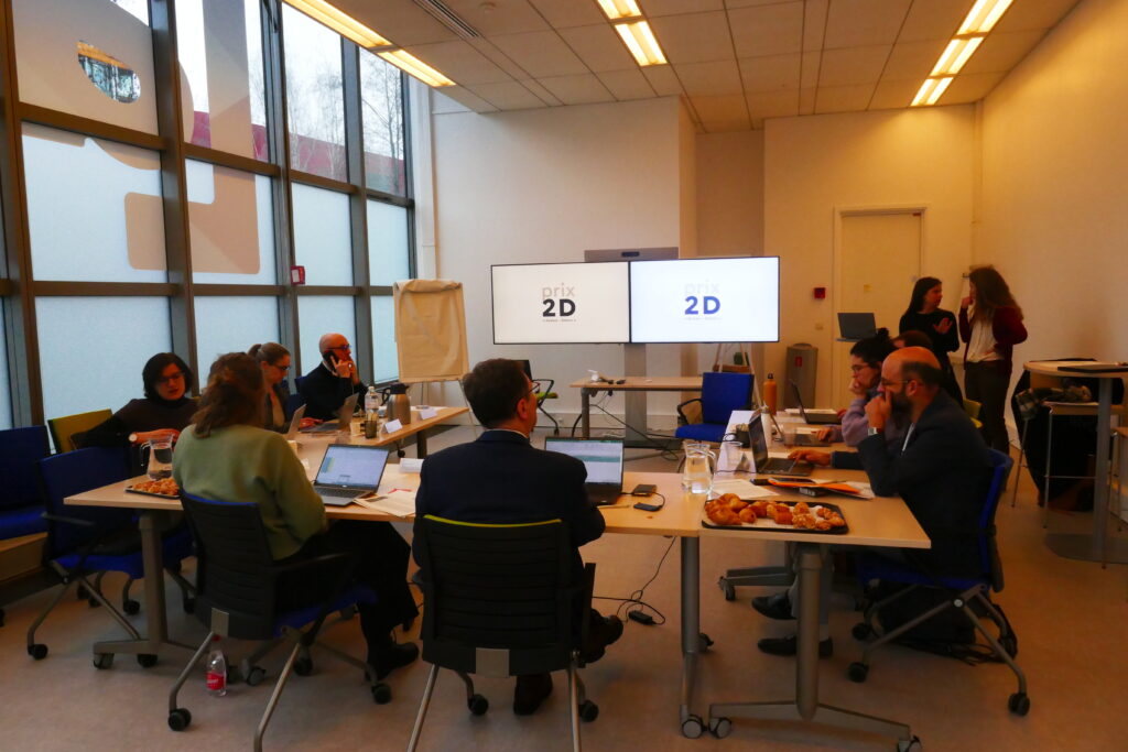 Photo du jury du prix 2D pour la 4e édition. Le jury est réuni autour d'une table, de dos, devant deux écrans