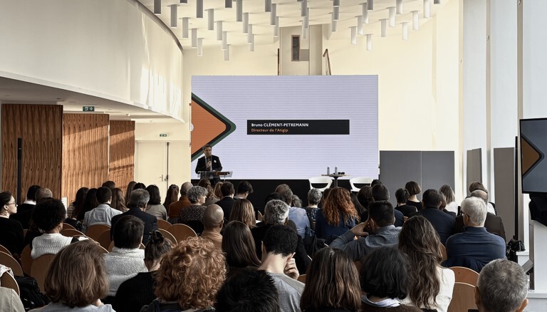 Photo prise lors de l'introduction des rencontres de l'Atigip, avec un groupe de personnes assises de dos en face d'une personne debout devant un écran